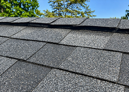 Replaced asphalt shingle ridge caps along the peak of a residential roof