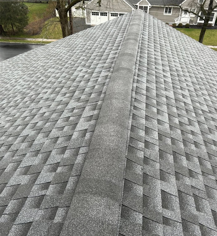 Storm-damaged asphalt shingle roof restoration showing repaired roofing areas