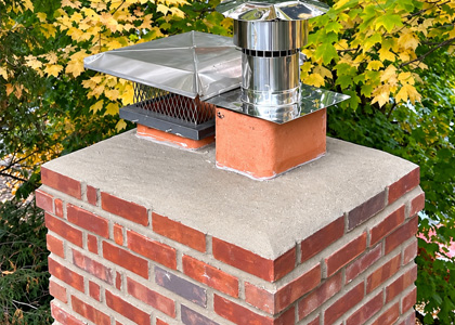 Brick chimney masonry restoration with repaired mortar joints and chimney components